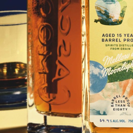 Two bottles and two glasses of Cascade Moon 15-Year-Old Barrel Proof, an under 80-proof, whisky-esque spirit