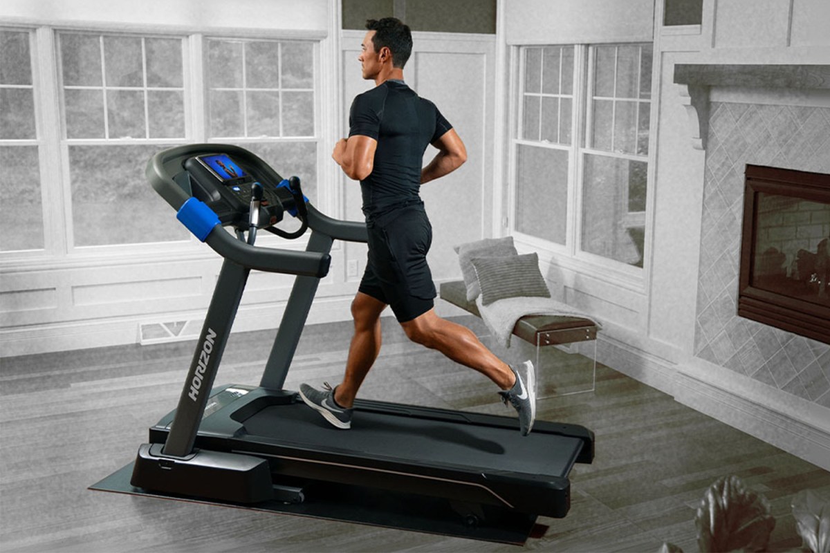 A man running on the Horizon Fitness 7.0 AT Studio Series Treadmill in a house. We tested and reviewed the popular treadmill.