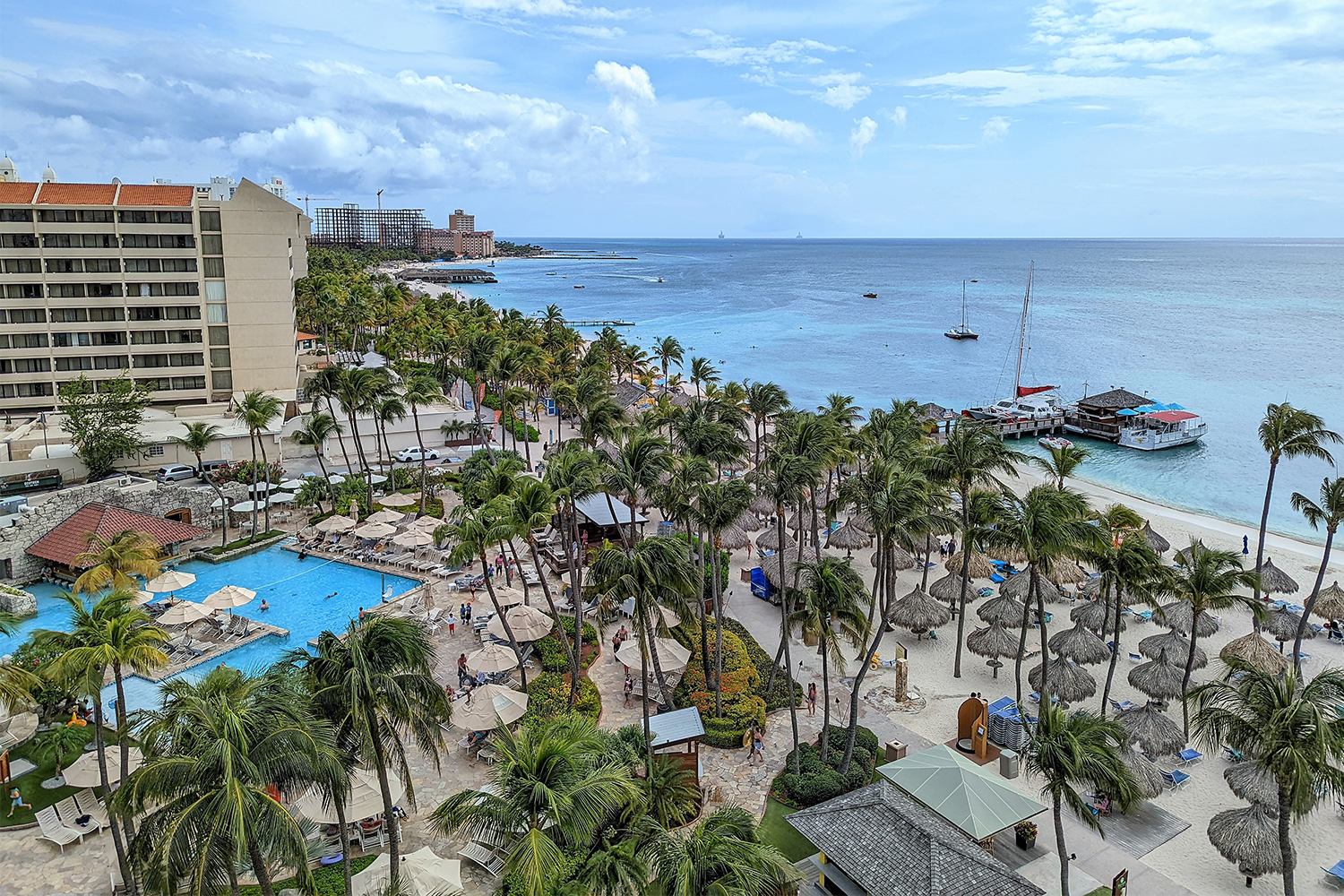 A view looking down at the pool, beach and ocean of the Hyatt Regency Aruba Resort
