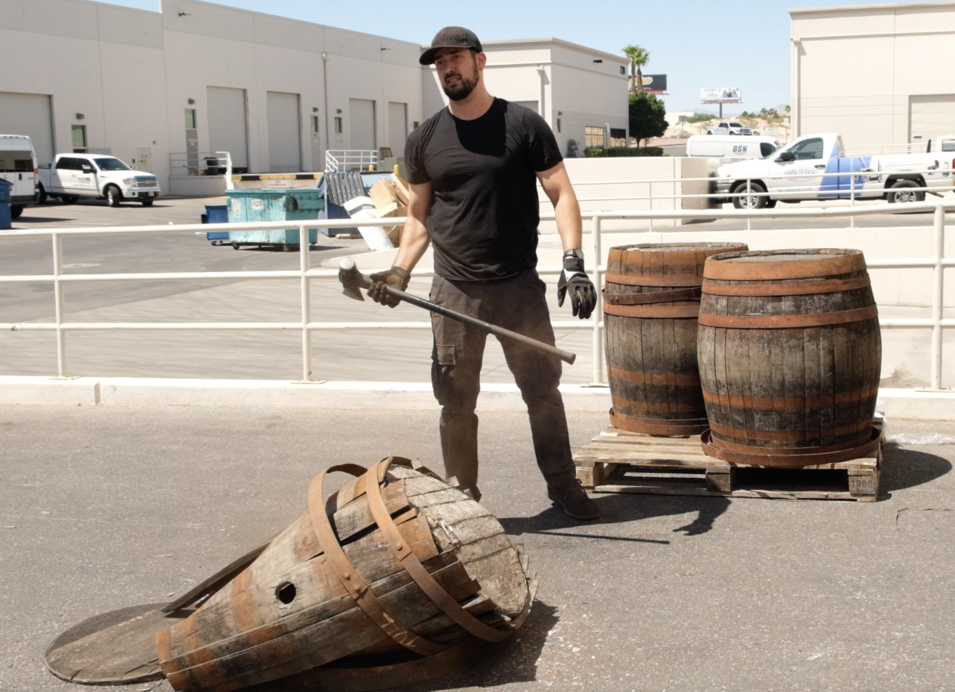 Broken Barrel founder Seth Benhaim breaking up a whiskey barrel in a parklng lot
