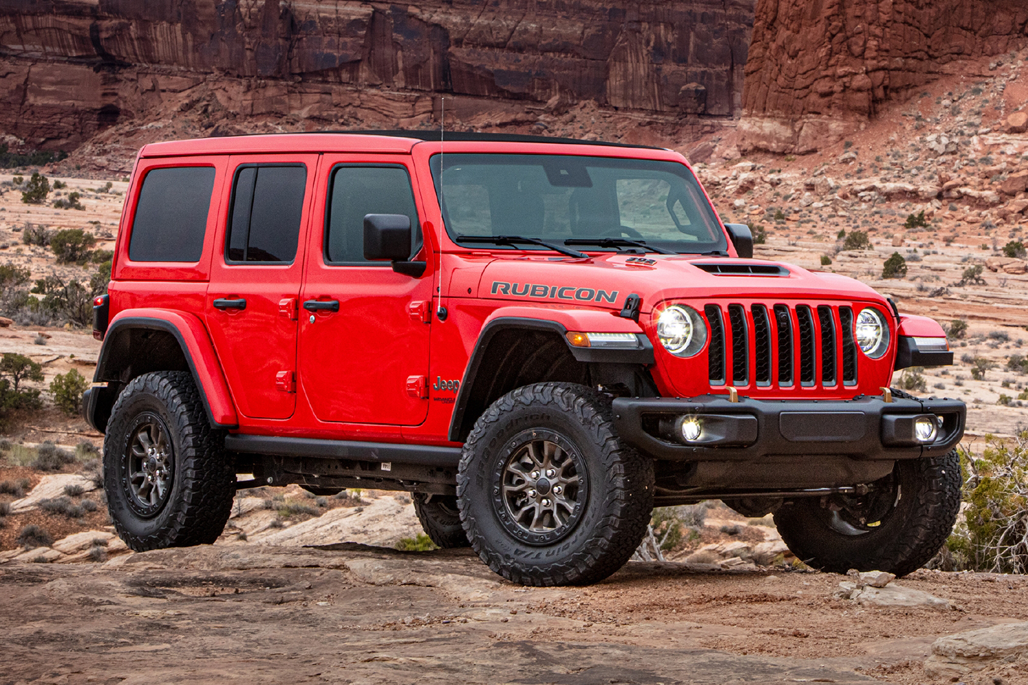 A red Jeep Wrangler Rubicon 392, an off-road SUV with a V8 engine, sitting in a canyon