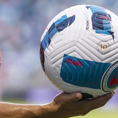 The NWSL-branded 10th anniversary match ball is carried by a player.