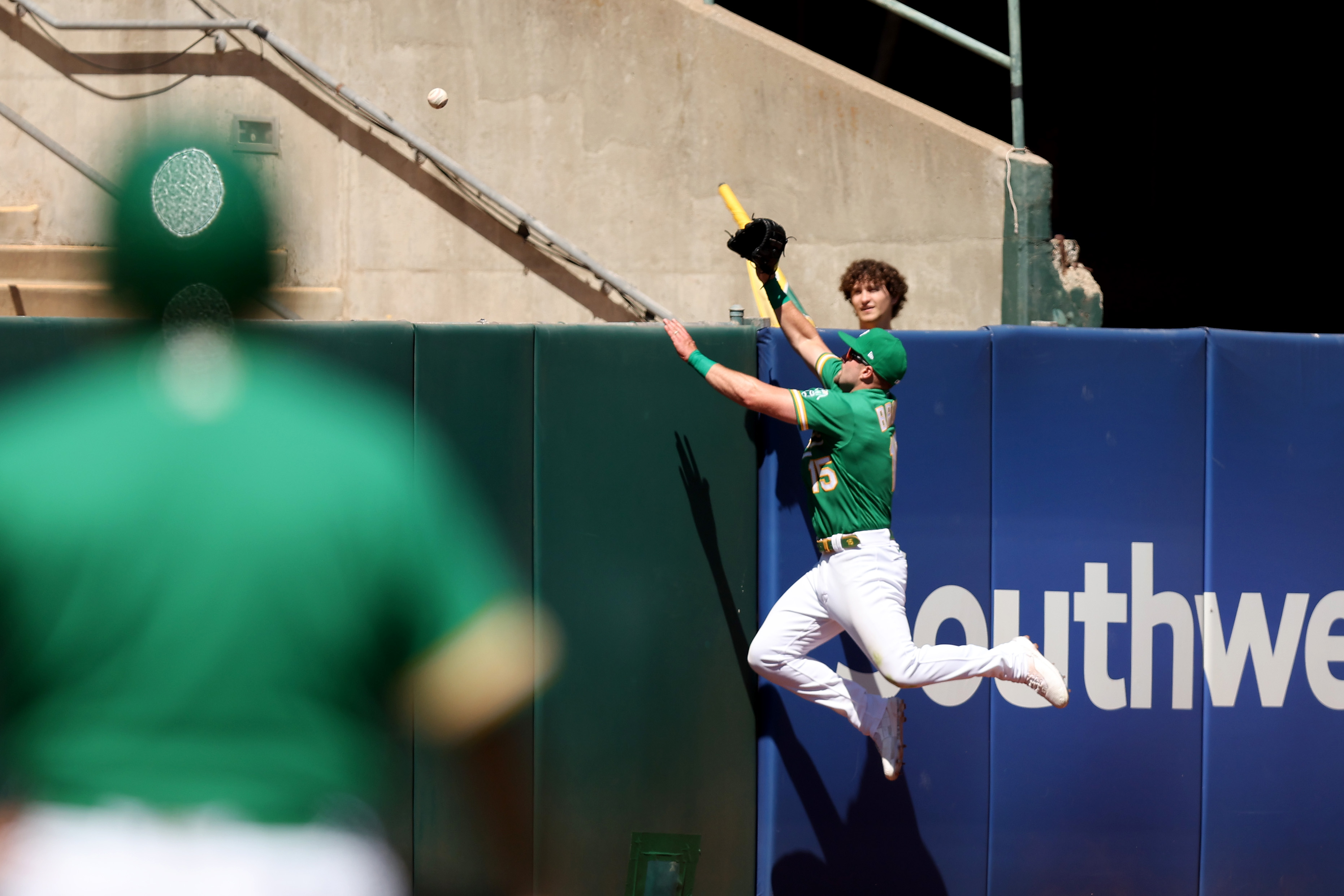 An Oakland Athletics outfielder tries to rob a home run.