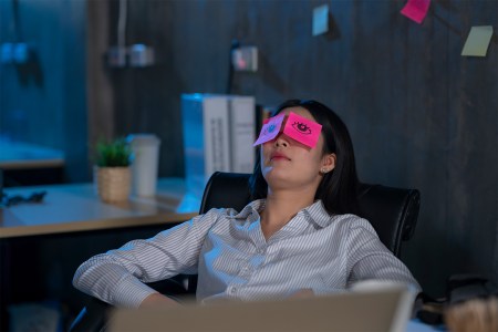 Young female work hard and sleep while working late