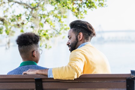 Father and child on a park bench talking