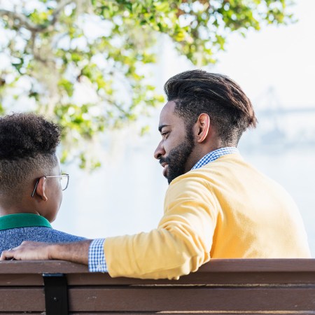 Father and child on a park bench talking