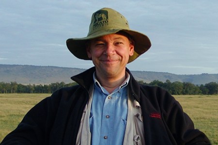 Travel writer and editor Don George in a hat photographed in the countryside