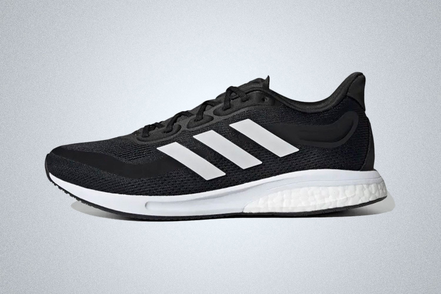 a black and white Adidas Supernova cushioned running shoes for men on a grey backgroud