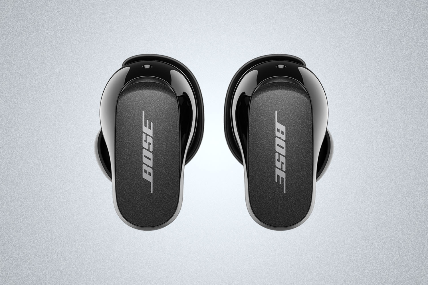 a pair of Black Bose QuietComfort II Earbuds on a grey background