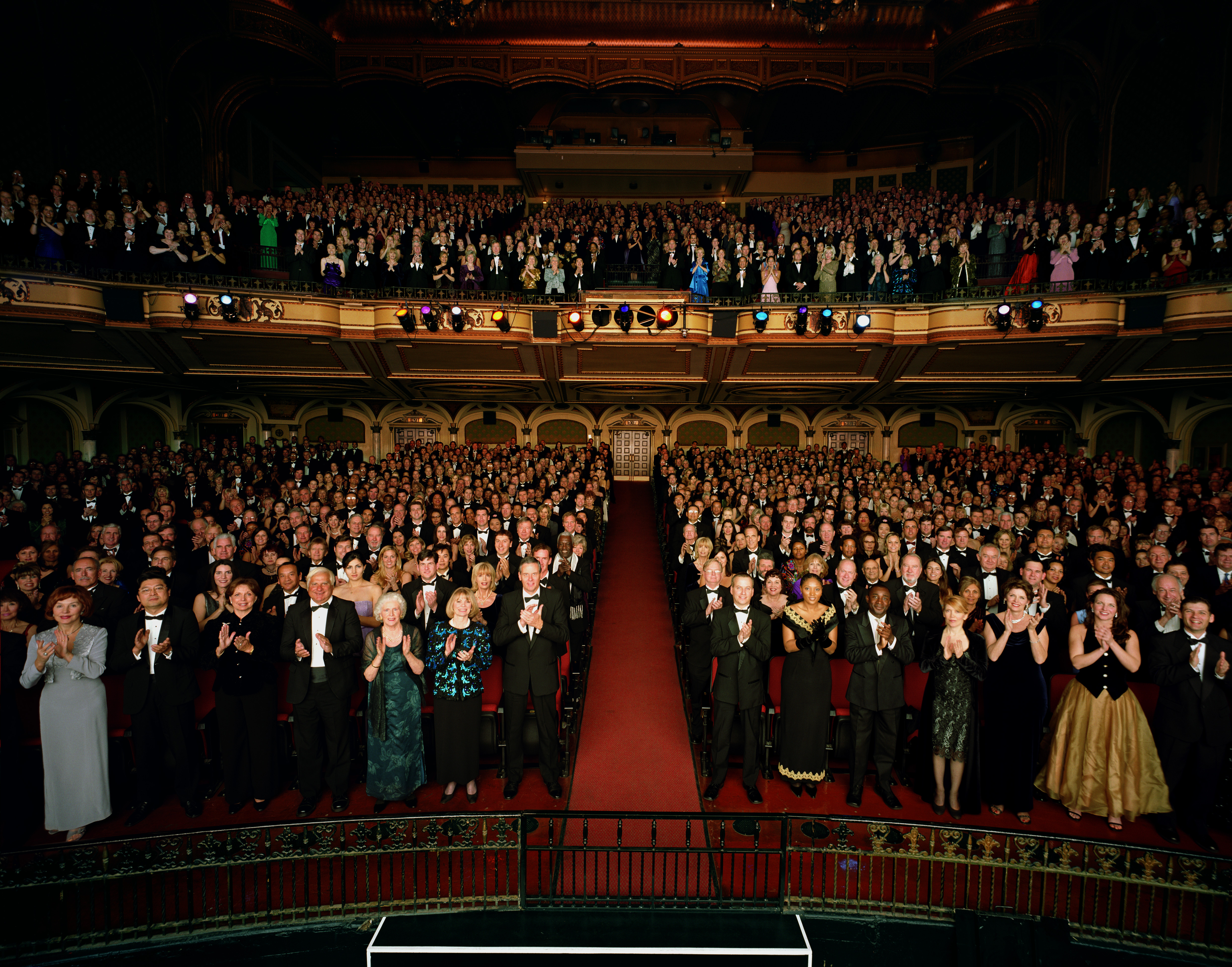 A crowd in a theater gives a standing ovation