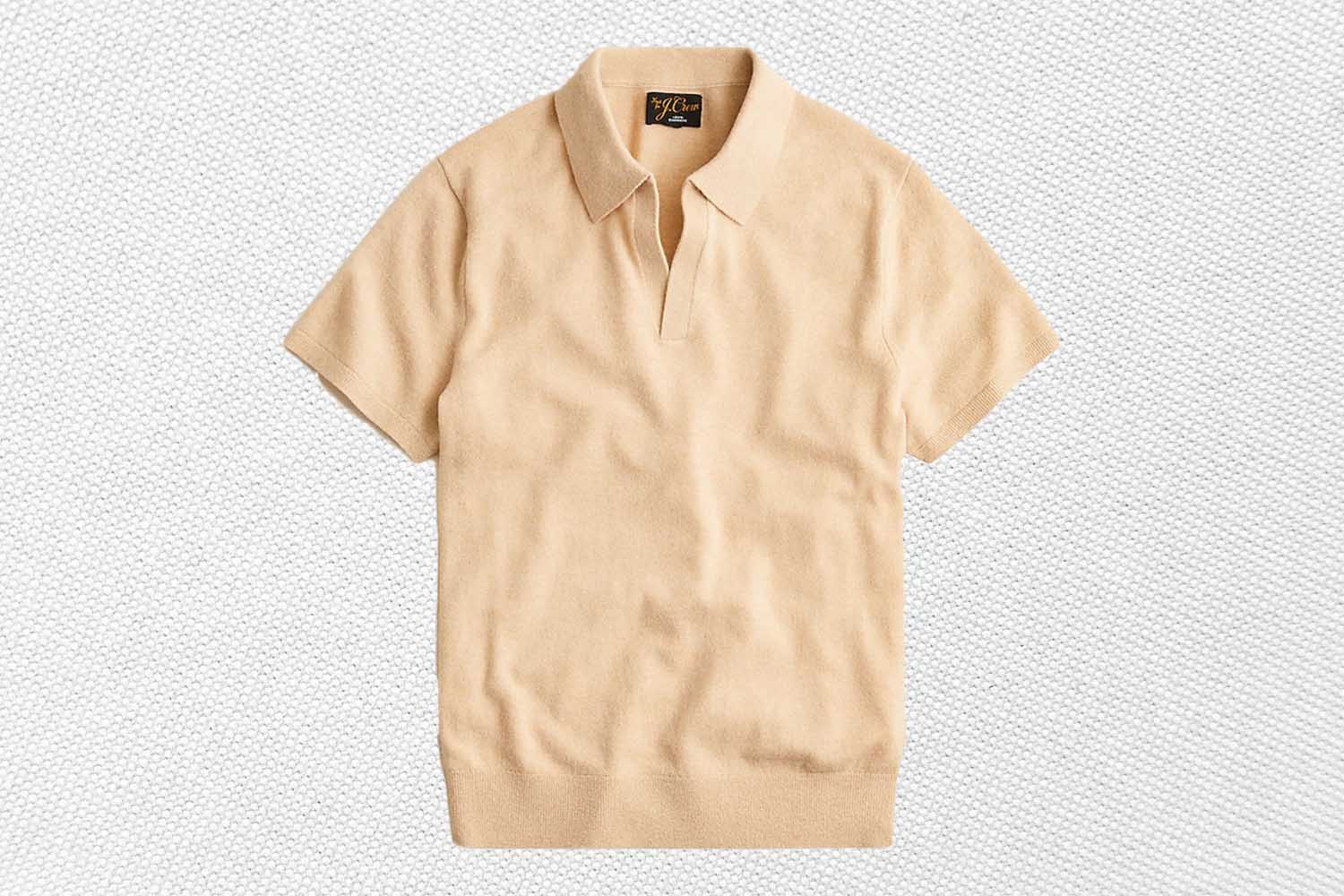 a cream cashmere polo from J.Crew on a textured white background
