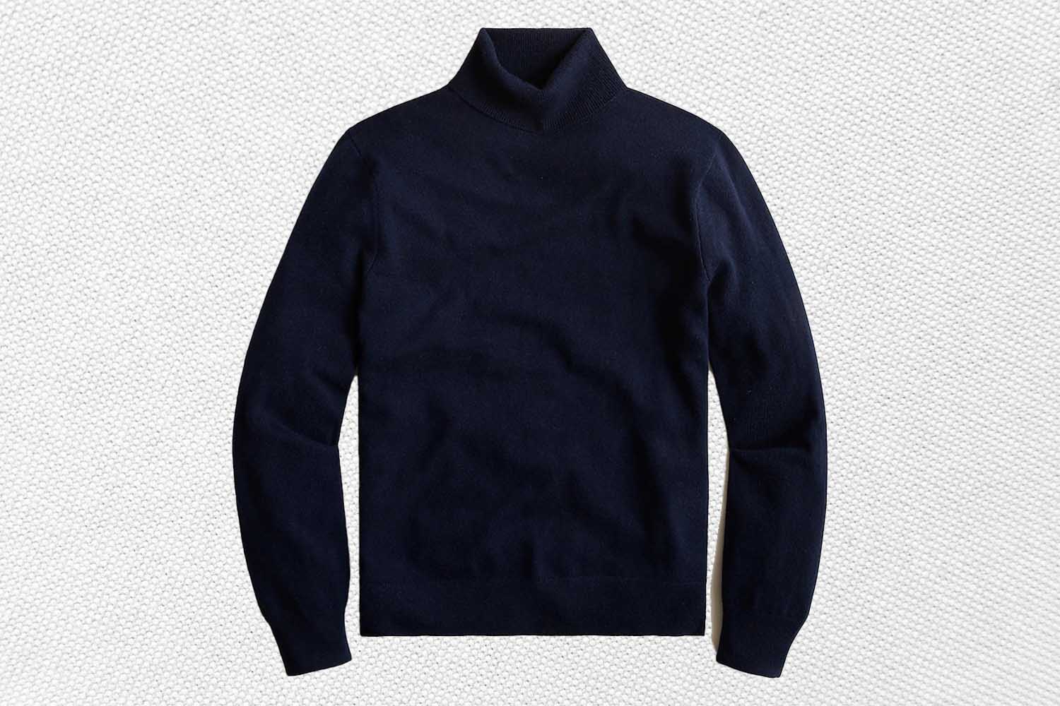 a navy cashmere turtleneck from J.Crew on a textured white background