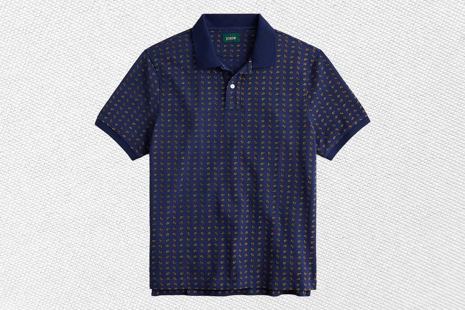a blue printed J.Crew polo on a grey background