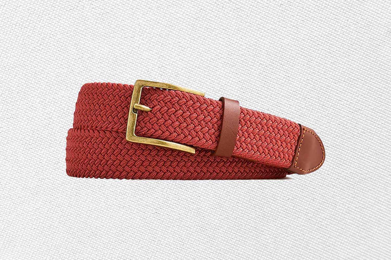 a red woven belt with a gold buckle from J.Crew on a grey background