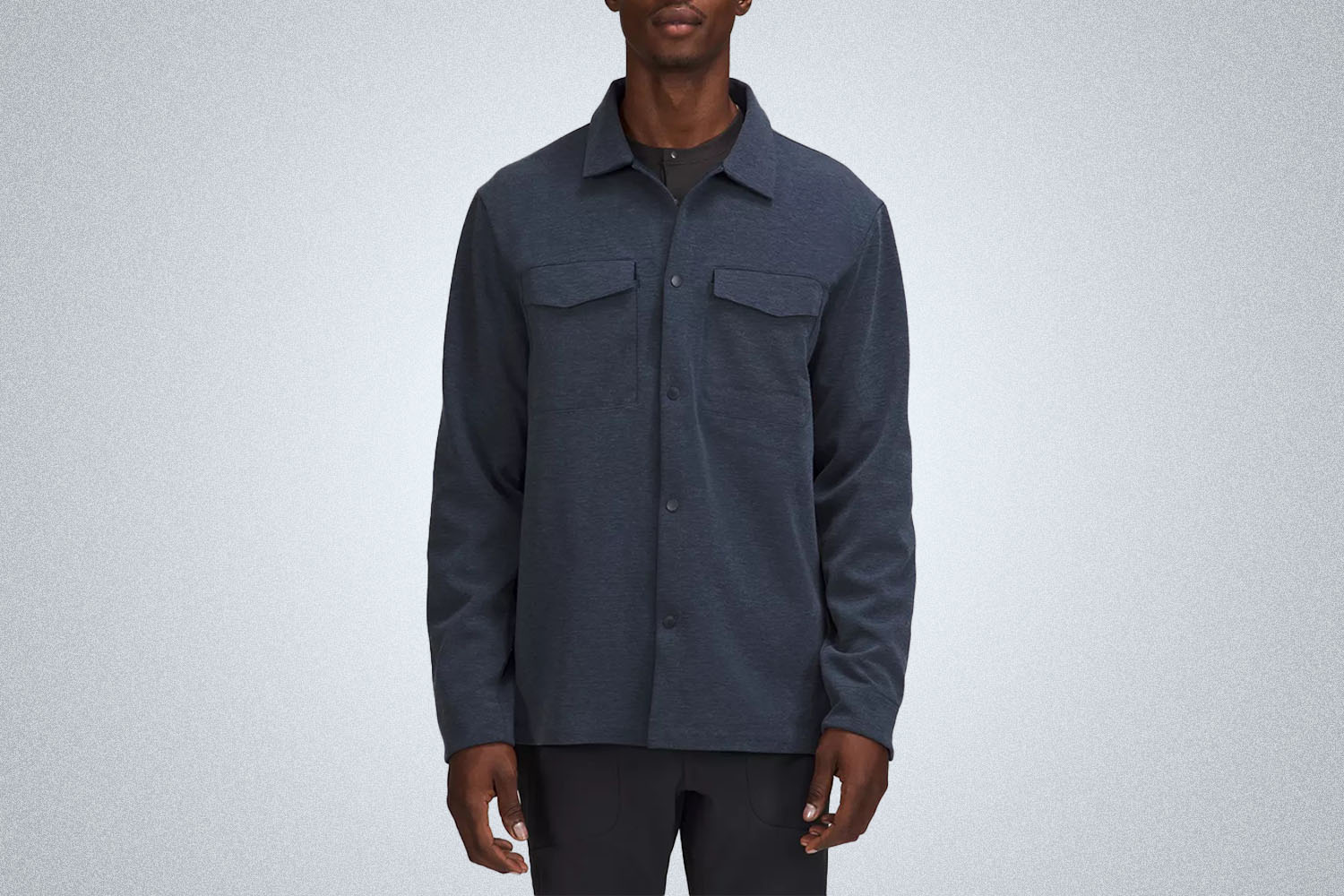 a model in a navy blue lululemon overshirt on a grey background