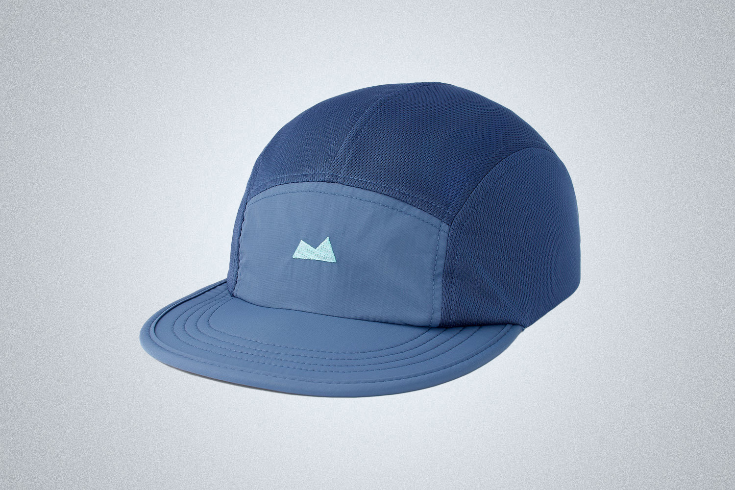 a two-toned blue hat with the Myles Apparel insignia on a grey background