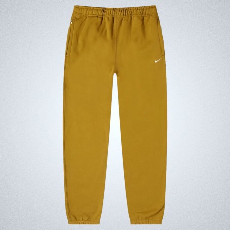 a pair of tan Nike sweatpants on a grey background