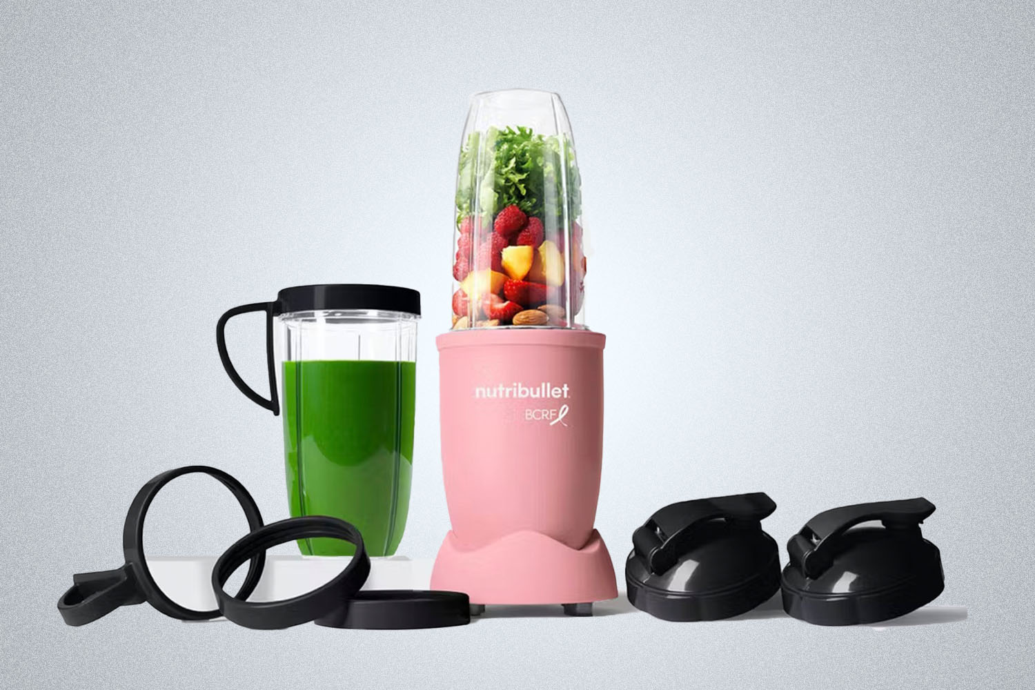 a pink Nutribullet and accessories on a grey background