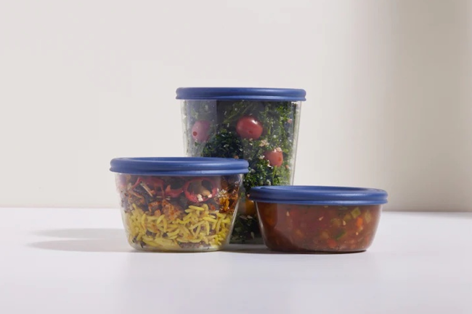 A trio of Our Place food containers on a gray background