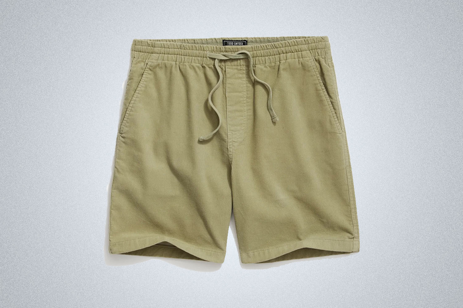 A pair of green corduroy shorts from Todd Snyder on a grey background