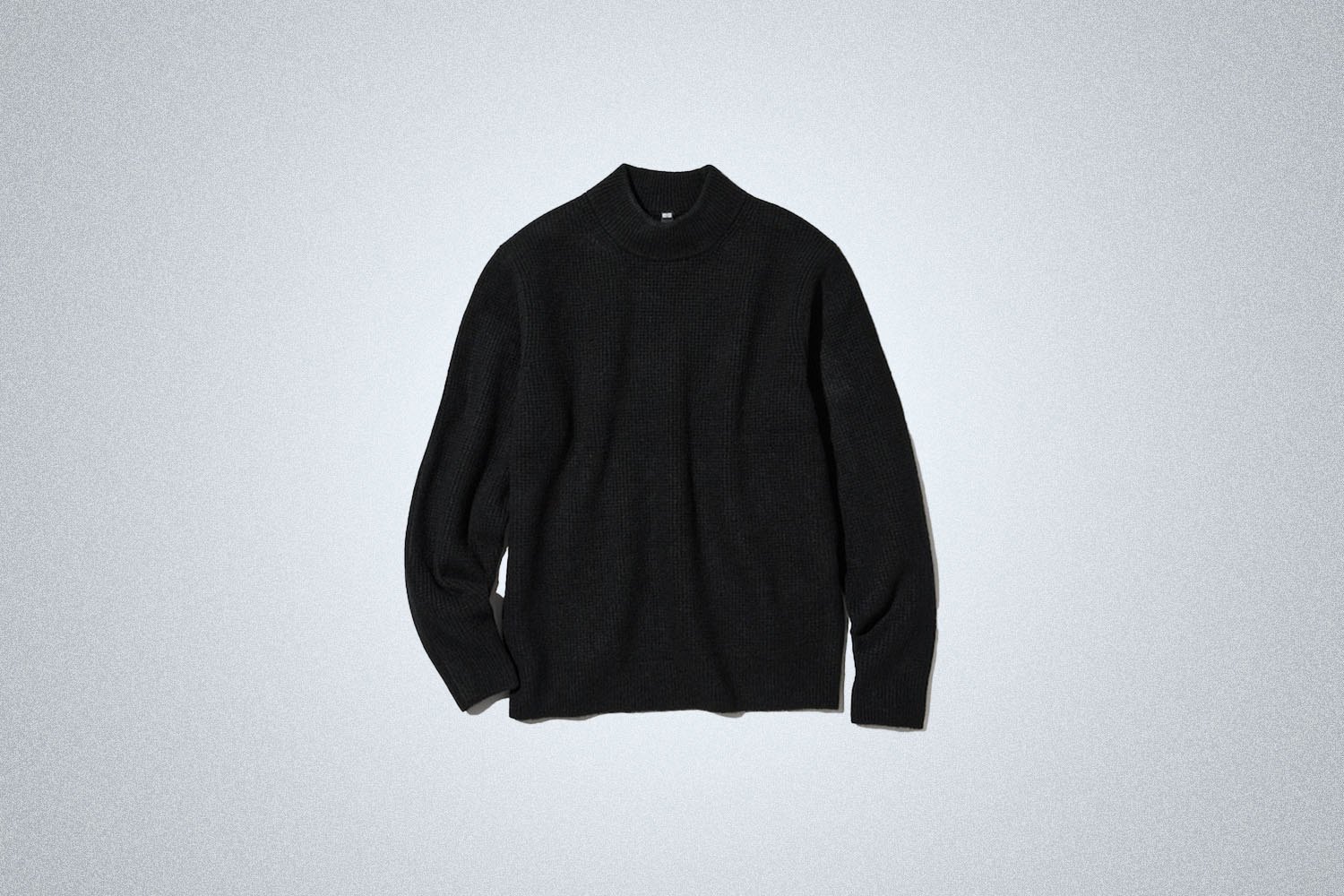 The Uniqlo Mockneck Sweater on a gray background
