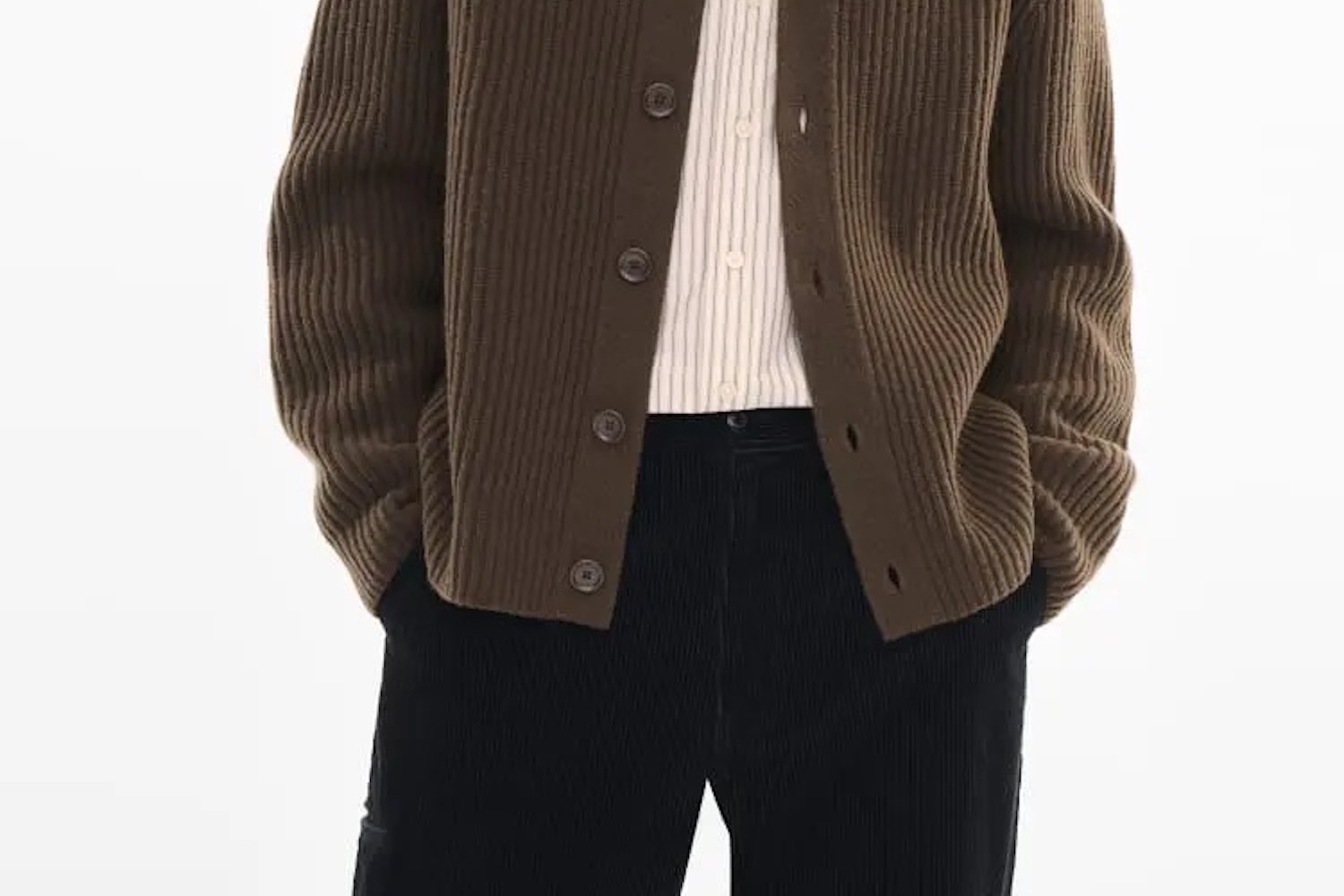 a model in a brown cardigan and black pants on a white background