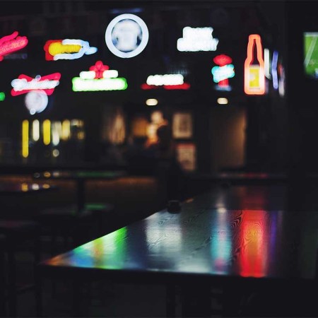 An empty bar with several beer signs (blurred). The booze industry has had some less-than-stellar numbers recently.