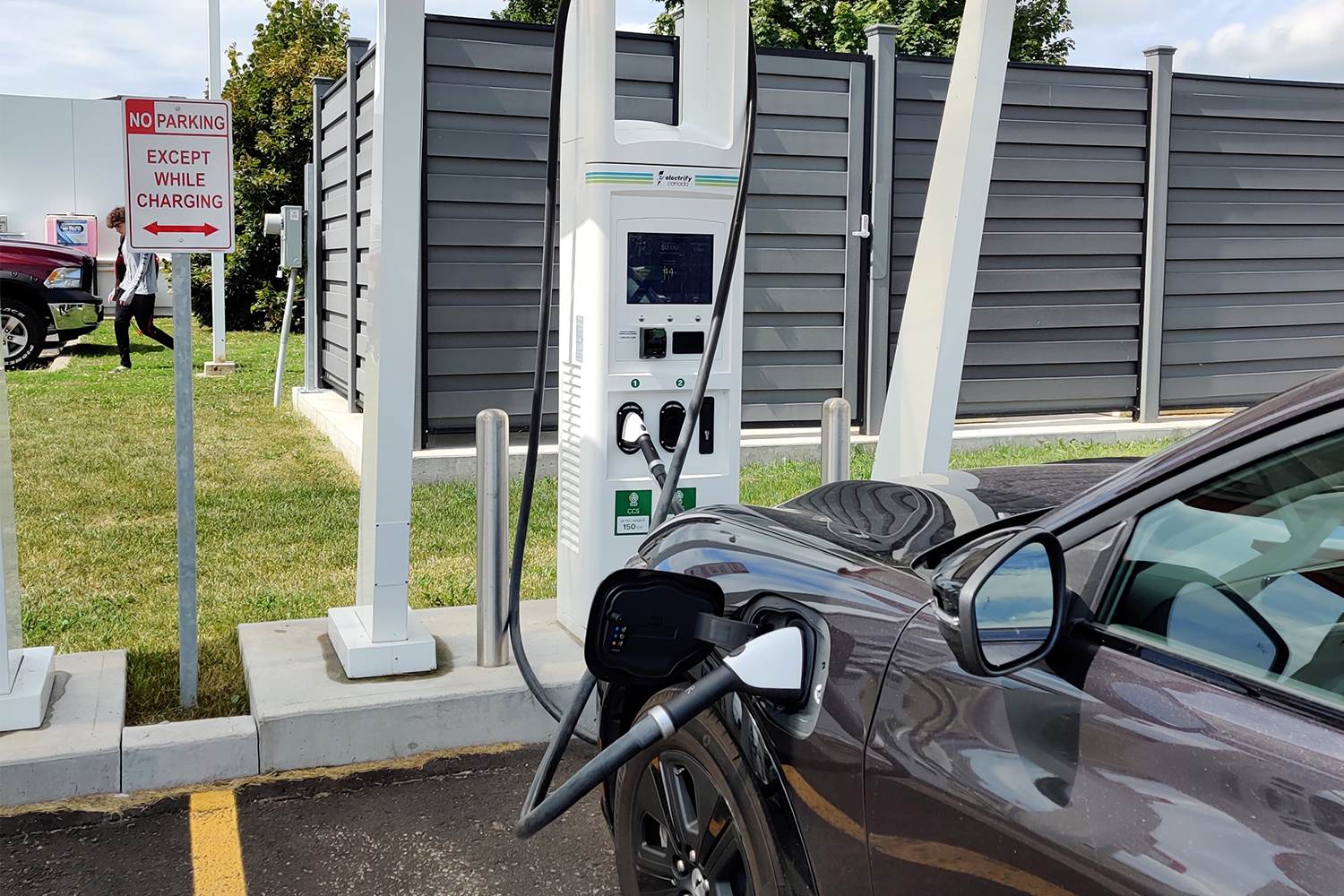 An Electrify Canada charging station in a parking lot with a Ford EV plugged in