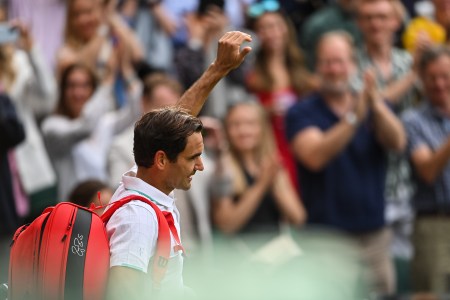 Roger Federer walks off the court at Wimbledon and waves to the crowd. He announced his retirement this week.