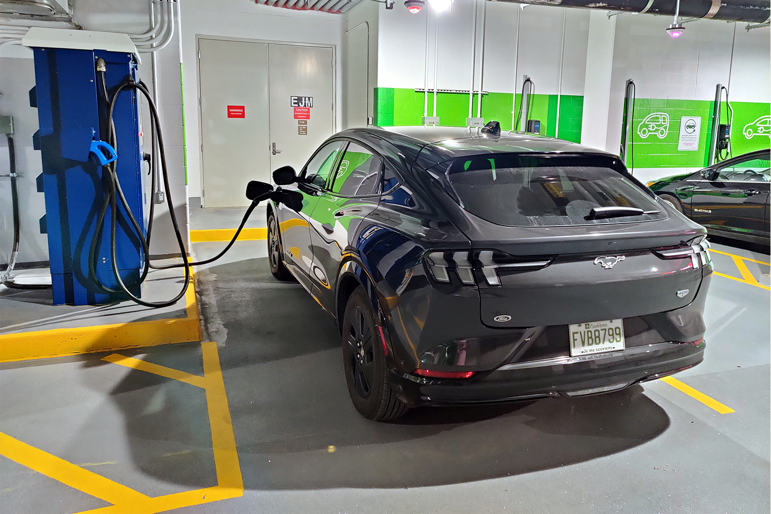 aA Flo EV charging station in an underground garage in Toronto with a Mustang Mach-E plugged in