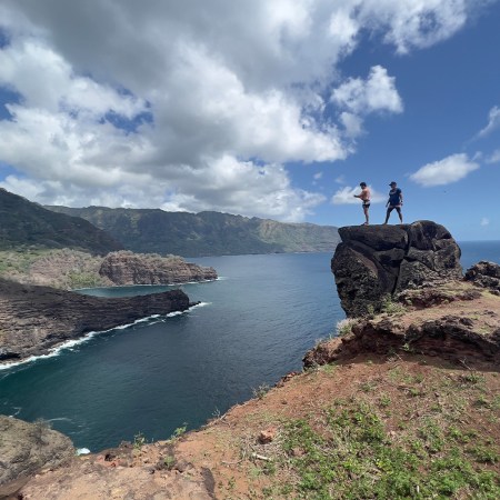 Two men standing on Virgin Rock in French Polynesia's Marquesas Islands