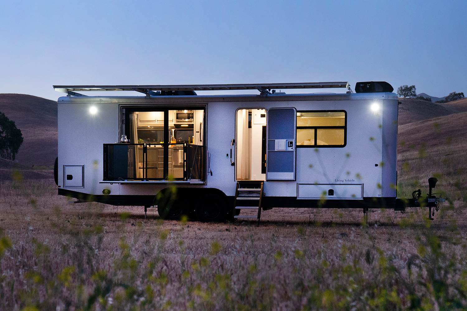 The Living Vehicle, an off-grid travel trailer, in a field at night