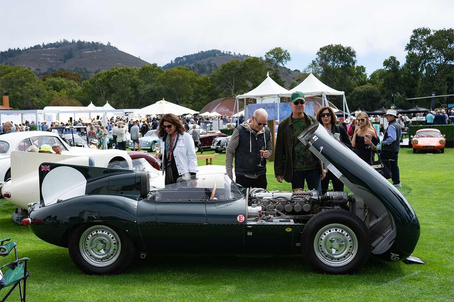 Spectators look into a vintage car at the Rolex Monterey Motorsports Reunion