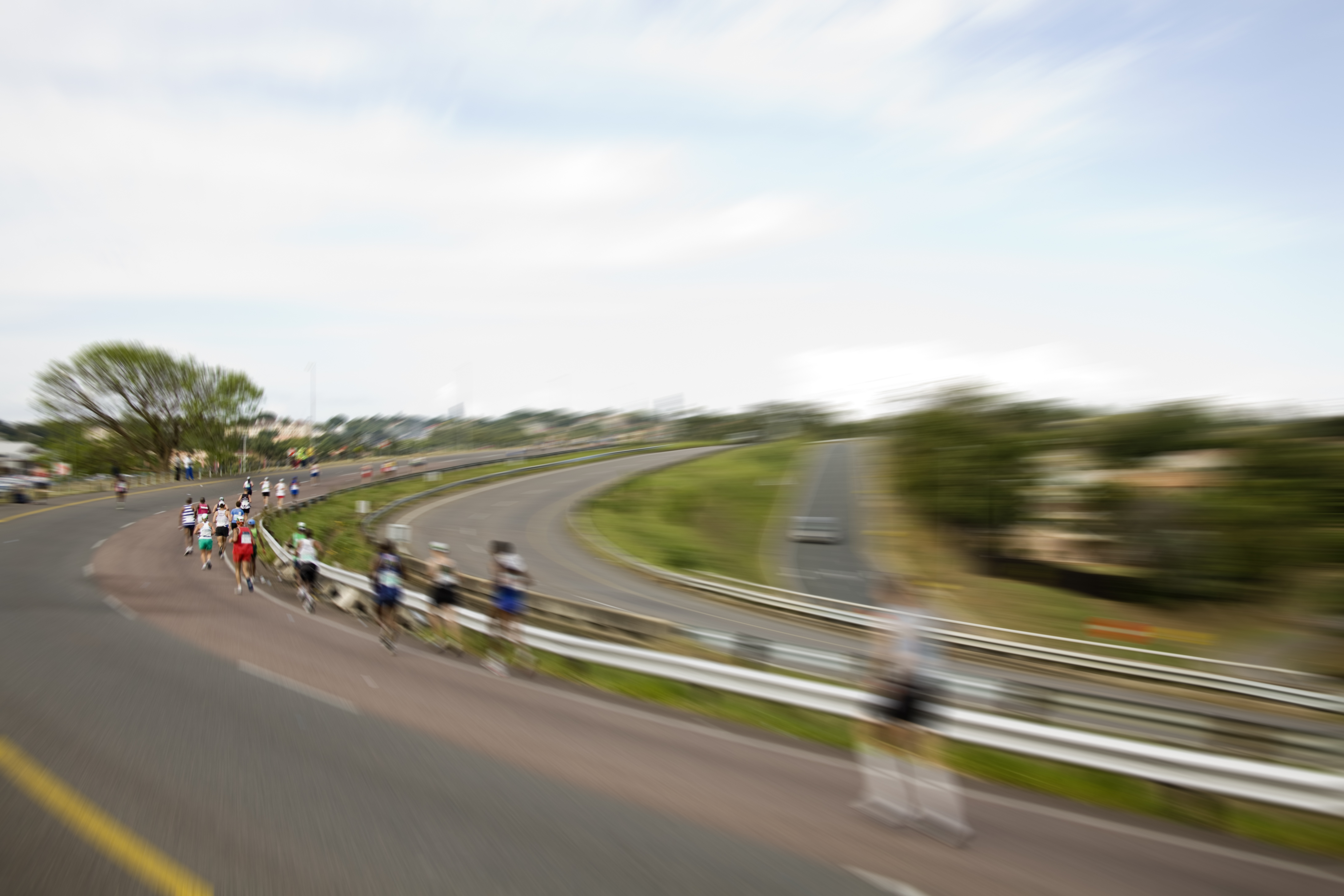 A group of runners racing along an empty street.