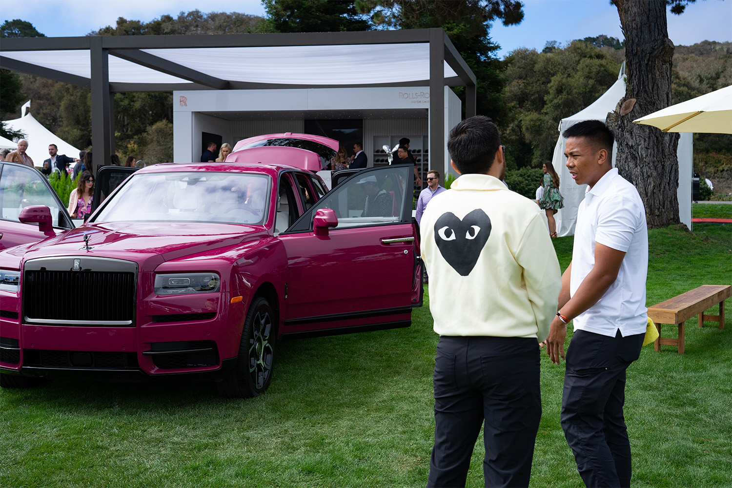 Men in front of a pink Rolls Royce