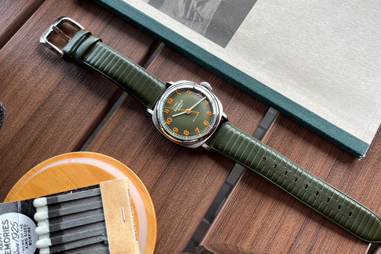 The Shinola Mechanic hand-wound watch in olive green sitting on a table. We tested and reviewed the new timepiece