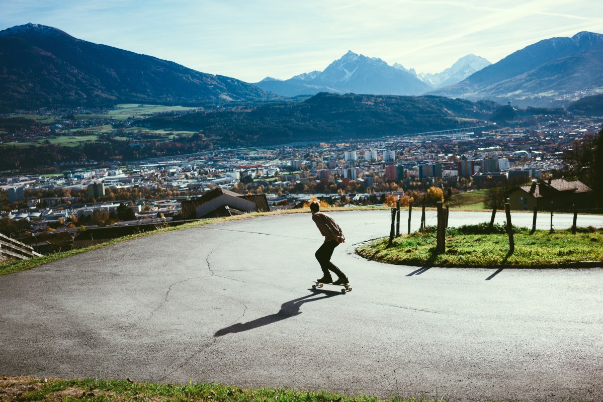Man riding on longboard in mountains