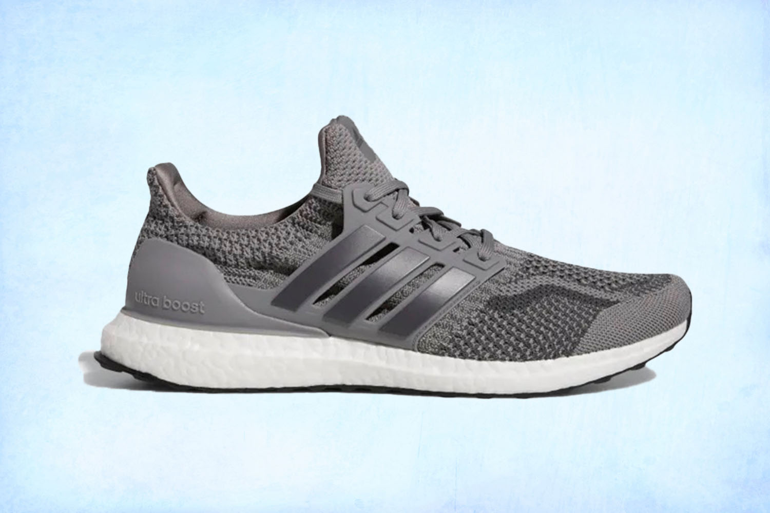 a pair of grey Adidas Ultarboost sneakers on a light blue background