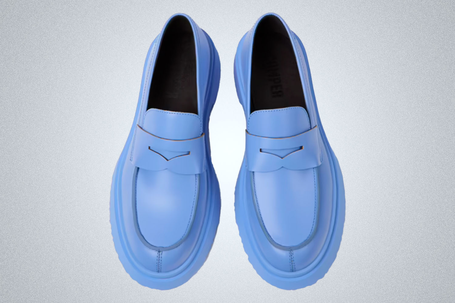 a pair of blue lug sole loafers on a grey background