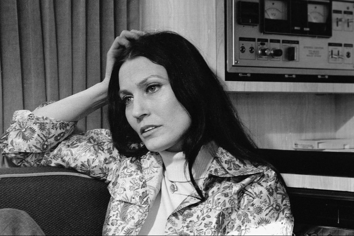Loretta Lynn rests her head on her hand and reclines on a couch near some audio equipment, February 24, 1975.