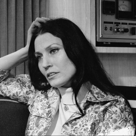 Loretta Lynn rests her head on her hand and reclines on a couch near some audio equipment, February 24, 1975.
