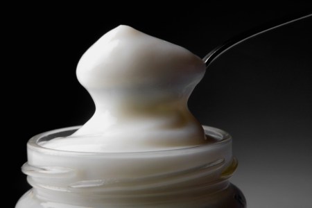 A close-up of a spoon in a jar of mayonnaise