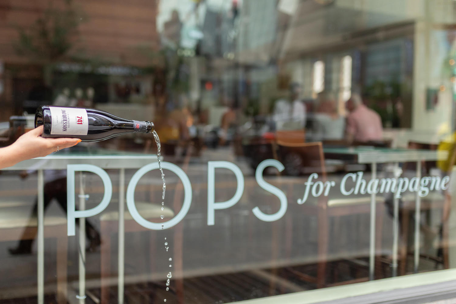 Pouring a Champagne bottle in front of Pops for Champagne in Chicago