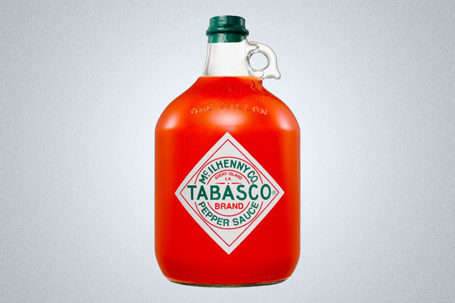 a gallon of Tabasco sauce on a grey background