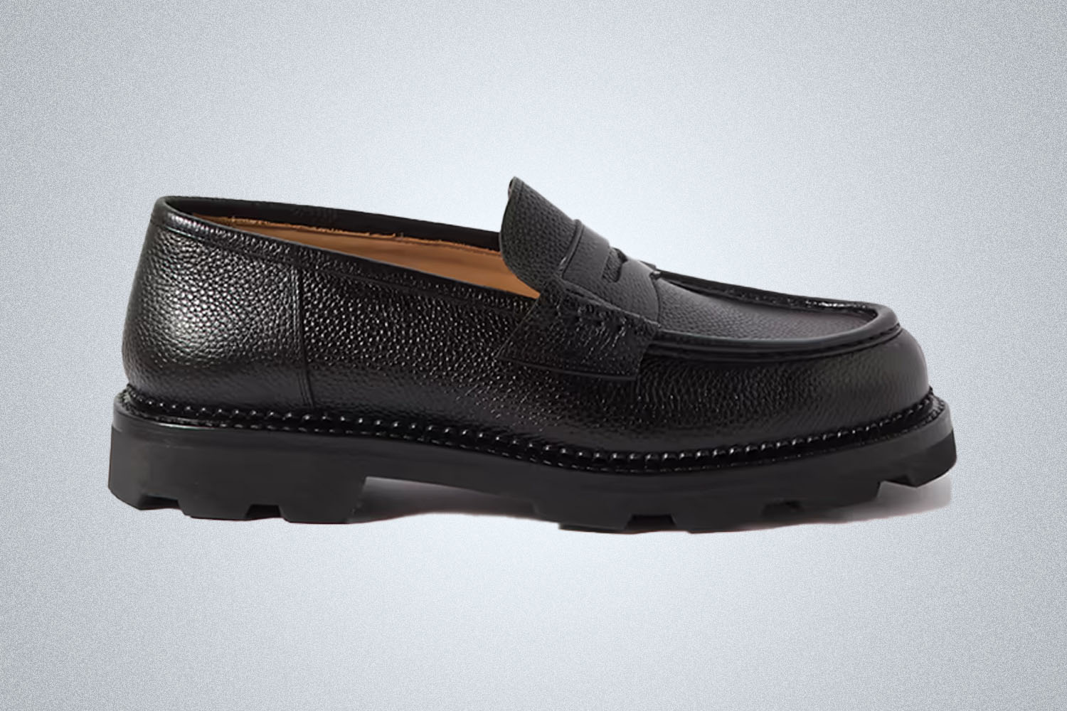 a pair of black Yuketen loafers on a grey background