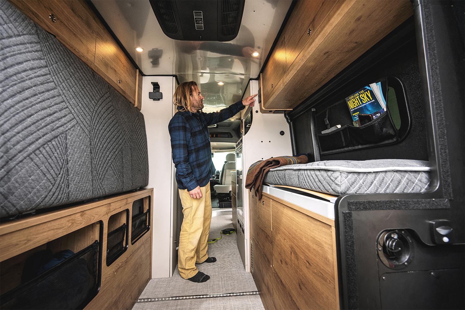 A man changes the settings inside his Airstream Rangeline camper van