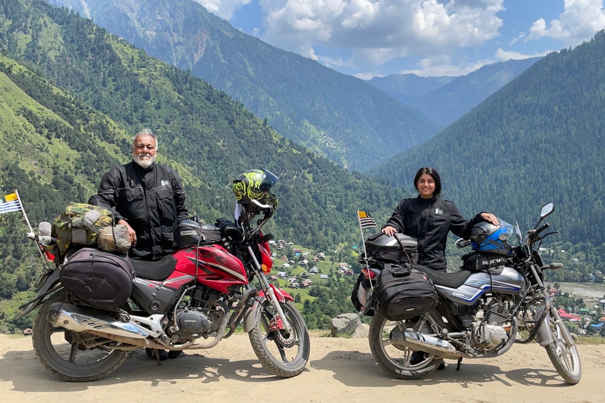 Qazi and Ghazal Farooqi posing in front of their motorcycles in the mountains of pakistan
