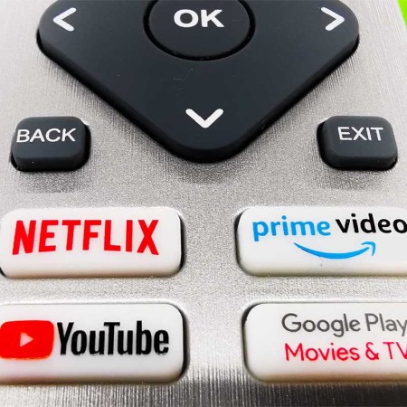 A detail of TV remote control with streaming platform buttons. We look at how Netflix and other streaming services might be immune to inflation.
