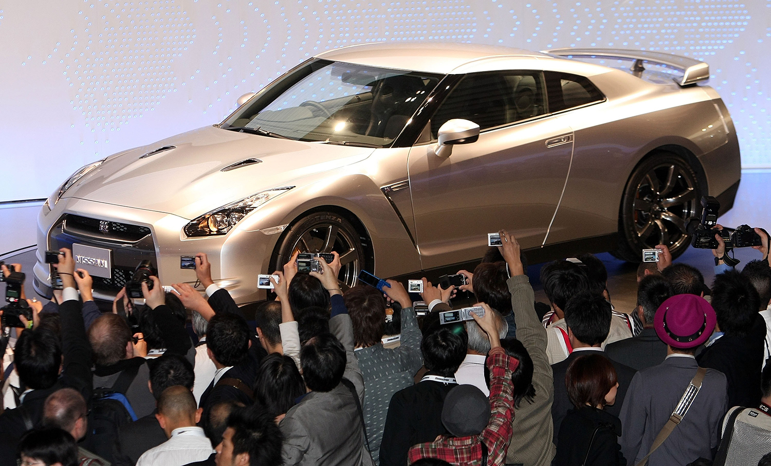 People attending the Tokyo Motor Show in 2007 raise their cameras to take photos of the new Nissan GT-R R35, which is today an overlooked sports car with supercar power