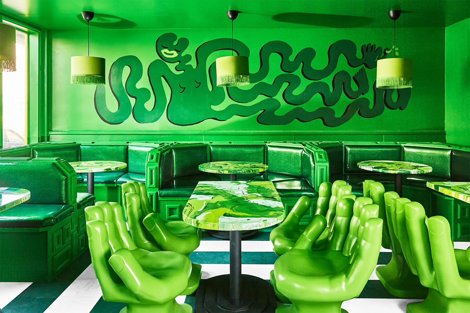The green dining room with hand-shaped chairs at Shuggie's, a food waste restaurant in San Francisco